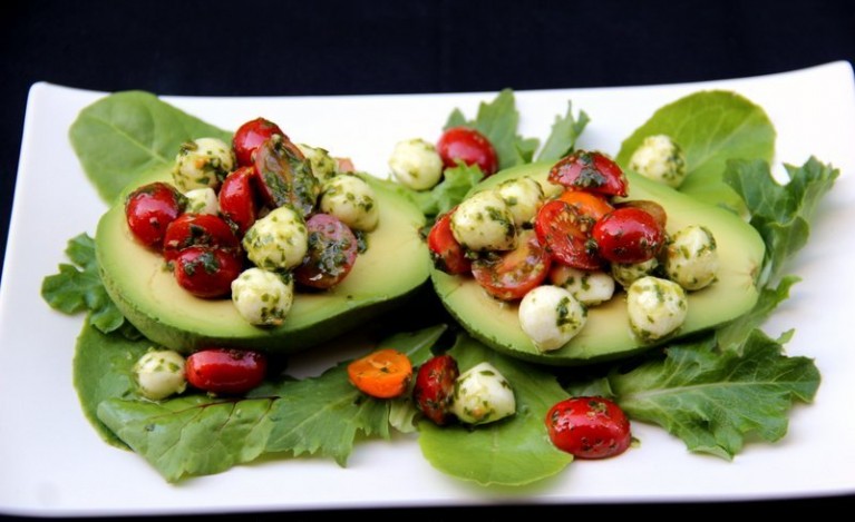 Use-a-spoon-to-fill-the-avocado-halves-with-the-caprese-filling